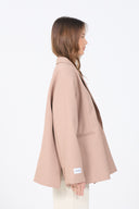 Woman wearing a beige coat on a white background