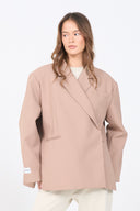 Woman wearing a beige blazer against a white background