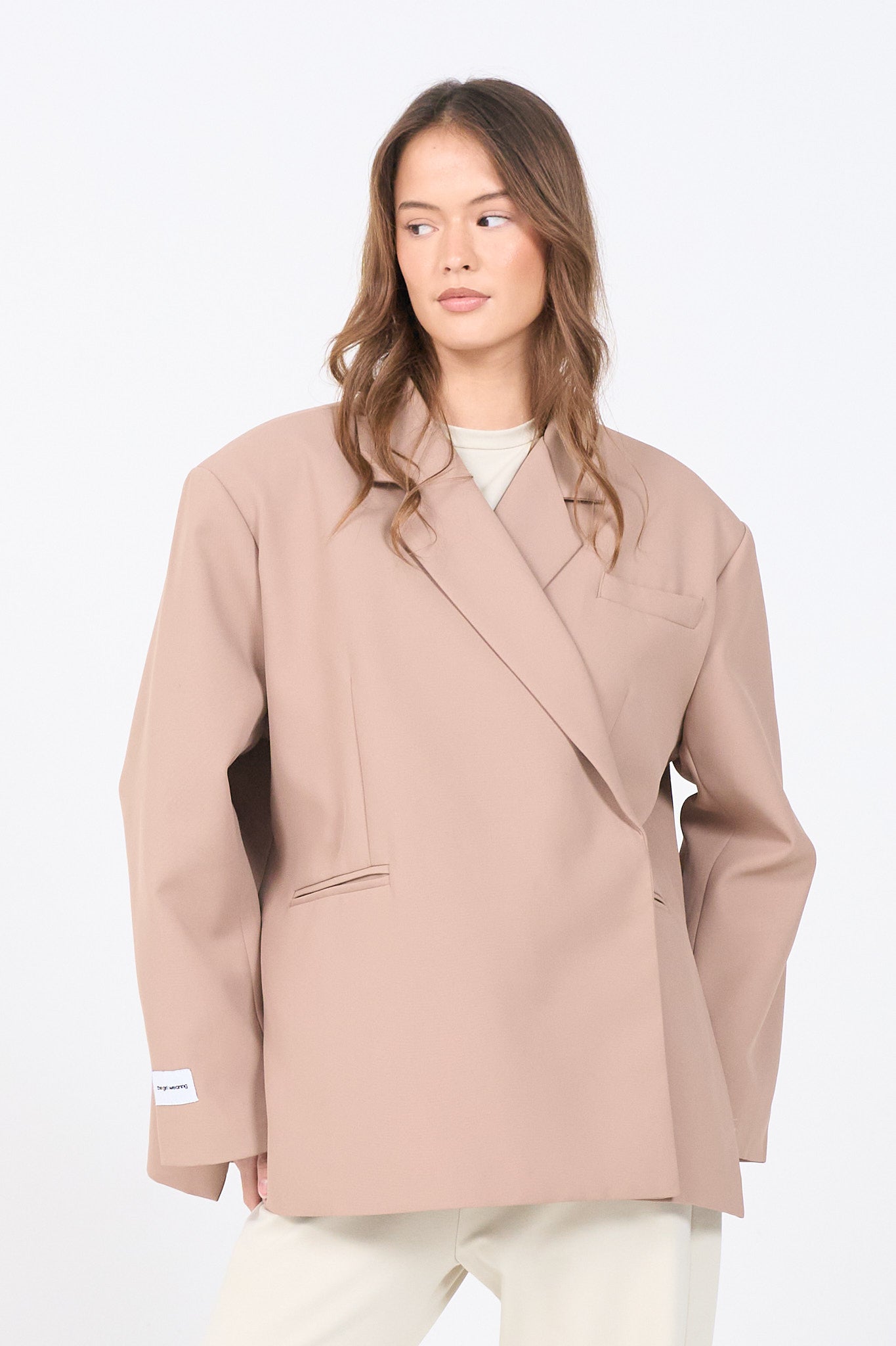 Woman wearing a beige blazer against a white background