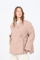 Woman wearing a beige coat on a white background